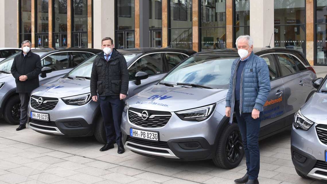 Gert-Uwe mende, Jens Hasselbächer und Leo Kutscheid vor Autos des Fahrservices. Foto: R+V Versicherung
