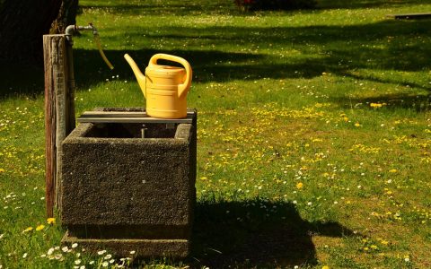 Gießkanne auf dem Friedhof am Brunnen, Grabsteine werden überprüft. Wasserrohrbruch.