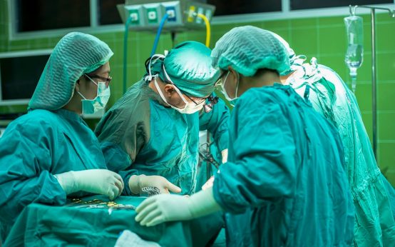 Regionale Gesundheitskonferenz, es geht um die Krankenhausreform. Das Bild zeigt Ärzte am Op-Tisch.